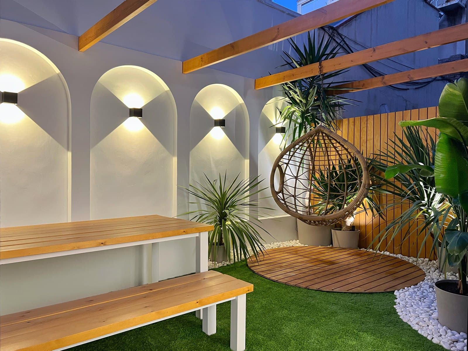 Patio interior ajardinado con zona chill out en una reforma en el Eixample de Barcelona realizada por CYR89